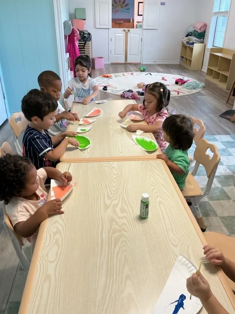 Children creating art together at a classroom table at Bright Haven