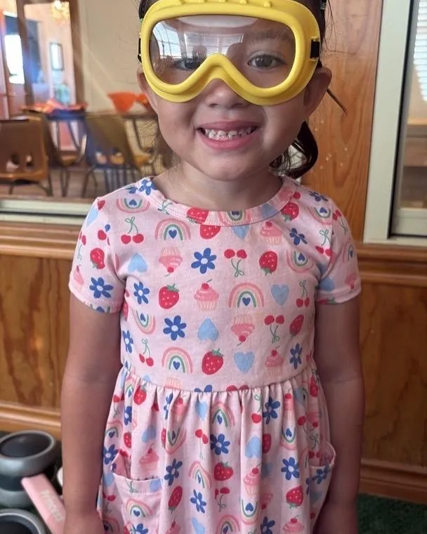 A Pre-K child exploring science goggles at Bright Haven