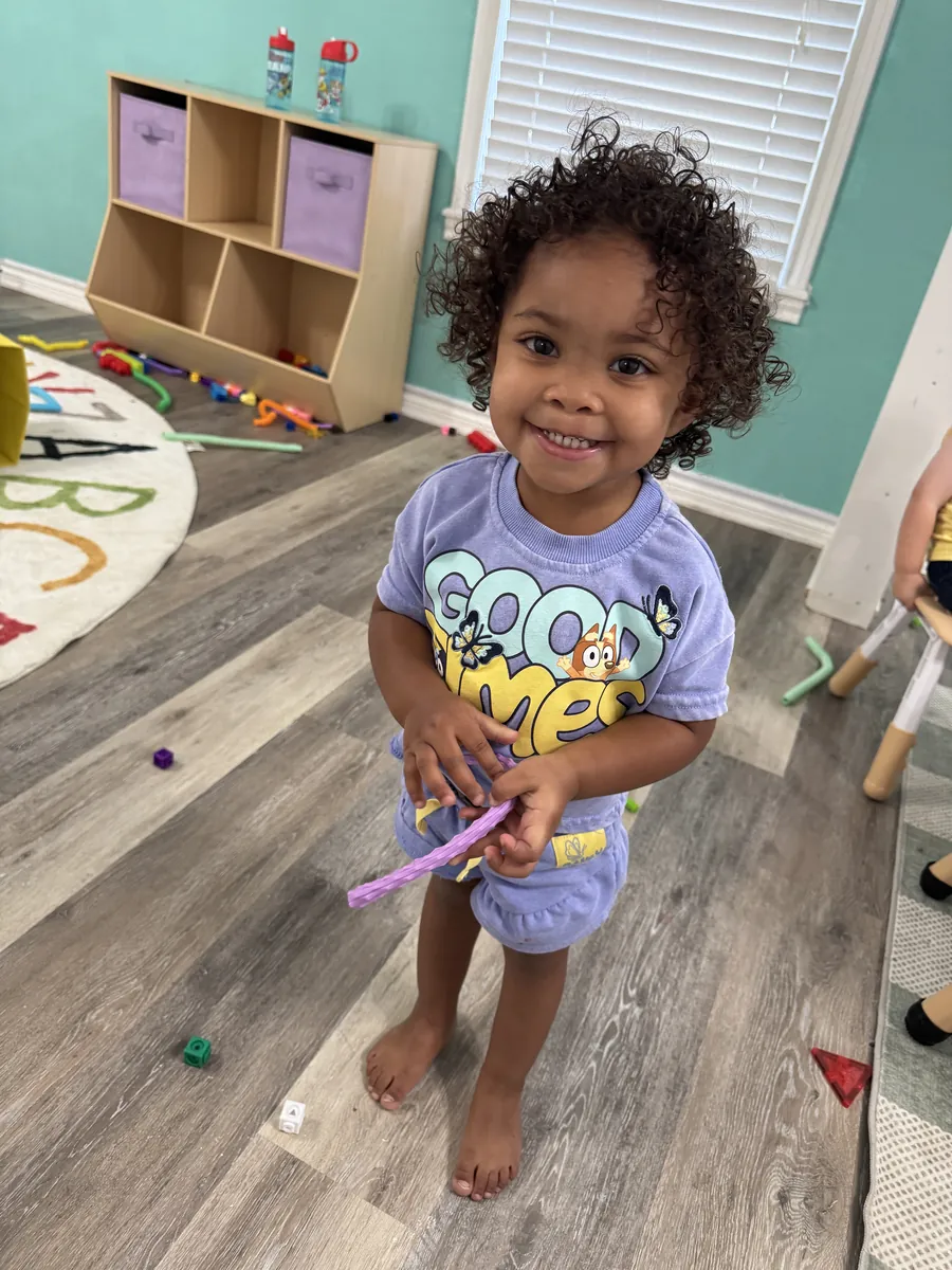 A smiling toddler at play at Bright Haven